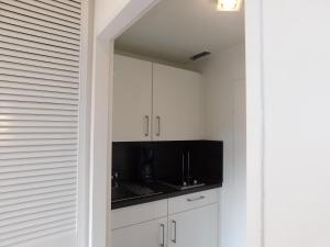 a kitchen with white cabinets and a black counter top at Wohnung Sonnenschein inkl Strandkorb vom 01 05-15 09 in Grömitz