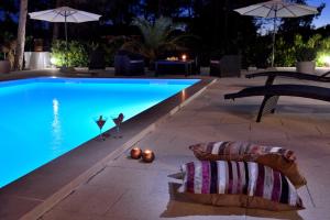 uma piscina à noite com guarda-sóis e cadeiras em Mam em Vir