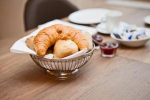 a basket of croissants and bread on a table at Kunsthotel "Drei König" am Marktplatz Stadt Lörrach in Lörrach