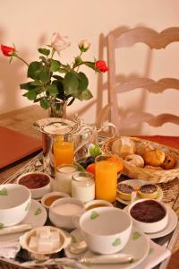 a table with a tray of breakfast foods and orange juice at Hôtel des Pyrénées in Saint-Jean-Pied-de-Port