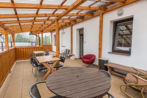 patio ze stołami i krzesłami oraz drewnianym sufitem w obiekcie Penzion Bedrč w mieście Benešov