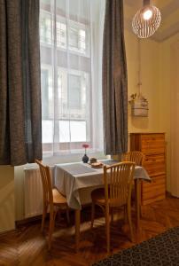 uma sala de jantar com uma mesa e cadeiras e uma janela em Capital Center Apartments Üllői em Budapeste