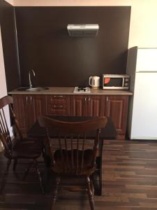 a kitchen with a table and a microwave and a refrigerator at Апартаменты в центре с парковкой in Cherkasy