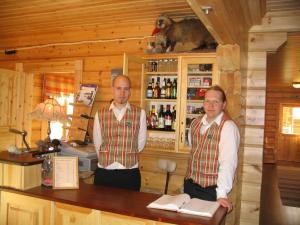 two men standing at a bar in a cabin at Guest House Haapaniemen Hirsikartano in Iisalmi