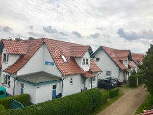 uma fila de casas com telhados vermelhos em Ferienhäuser Liethmann Haus 3 W 1 em Timmendorf