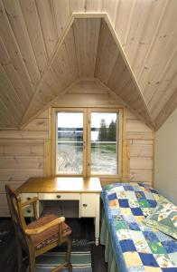 a bedroom with a desk and a bed in a cabin at Guest House Haapaniemen Hirsikartano in Iisalmi