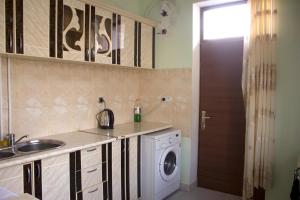 a kitchen with a sink and a washing machine at Tatev Shinuhayr Hotel' in Shinuhayr