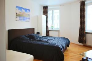 a bedroom with a bed with a black comforter at Prestige Vienna Apartment in Vienna