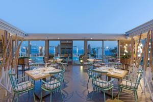 un restaurant avec des tables et des chaises sur un balcon dans l'établissement Anastasia Hotel & Suites Mediterranean Comfort, à Karistos