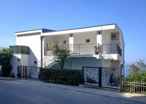 uma casa branca com uma varanda e uma rua em Sunset Apartments em Ulcinj