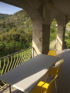 Santa-Lucia-di-TallanoにあるVILLA SANTINE AVEC TERRASSES et VUE PANORAMIQUE meublé tourisme 4 étoilesの白いテーブルと椅子付きのバルコニー