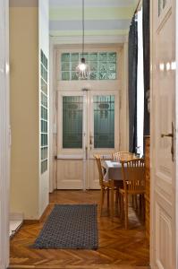 d'une salle à manger avec une table, des chaises et une fenêtre. dans l'établissement Capital Center Apartments Üllői, à Budapest