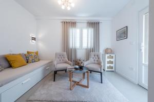 a living room with a couch and two chairs at Apartments Estrella in Dubrovnik