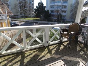 ビンツにあるFeWos direkt am Strand , mit Balkon und teilweise mit Meerblick, Haus Strelasund, Binzの白い柵の付いたベランダの椅子2脚