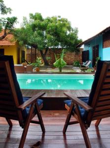 a pair of chairs sitting next to a swimming pool at Coco Country Homes in Melaka