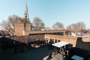 برايفت إن-سويت روم @ ليفربول ستريت، بريك لن في لندن: فناء على السطح مع طاولات وكراسي وكنيسة