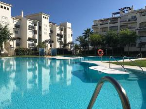 una gran piscina frente a algunos edificios en 2239-Lovely 2 bedrooms with pool and paddle court en Manilva