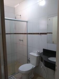 a white bathroom with a toilet and a sink at Flex Hotel in Três Lagoas +23 photos