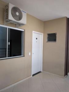 a room with a white door and a fan at Flex Hotel in Três Lagoas