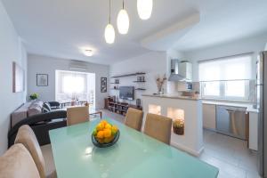 a kitchen and living room with a table and chairs at Apartments Estrella in Dubrovnik