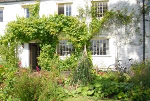 a white house with a garden in front of it at Shepherds Rest Bruton in Bruton