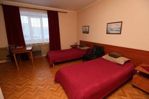 ウシンスクにあるVeneciaのベッド2台とテーブルが備わるホテルルームです。