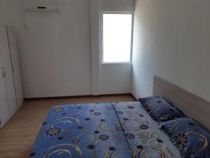 a bedroom with a bed with blue sheets and a window at Riverside Appartment in La Gaulette