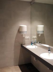 a bathroom with two sinks and a large mirror at Lækur Guesthouse in Reykjavík