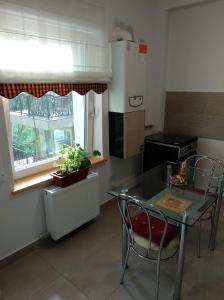 cocina con mesa, sillas y ventana en Apartament Ramona en Braşov