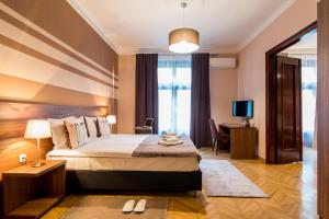 a hotel room with a large bed and a desk at Apartments Top Central 3 in Belgrade