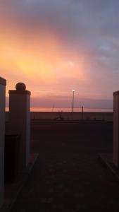 a sunset on the beach with the ocean in the background at Kleines Nest Bed and Breakfast in Walvis Bay