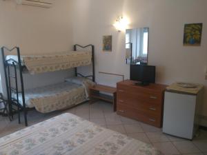 a bedroom with two bunk beds and a television at B&B Home Sweet Home in Diano Marina