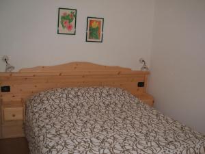 a bedroom with a bed and two pictures on the wall at Agritur Maso Talpina in Mori