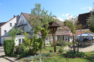 un jardín frente a una casa blanca en Hotel Gewürzmühle en Berching