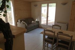 ein Wohnzimmer mit einem Sofa und einem Tisch in der Unterkunft Le gite du grand cèdre - proche des gorges du Verdon in Allemagne-en-Provence
