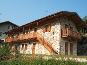 una casa de piedra con balcones de madera. en Agritur Maso Talpina en Mori