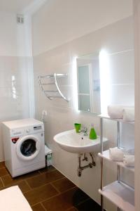 a bathroom with a washing machine and a sink at Exclusive Vienna Apartment in Vienna