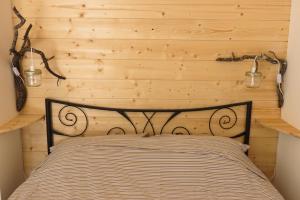 een bed in een kamer met een houten wand bij Le gite du grand cèdre - proche des gorges du Verdon in Allemagne-en-Provence