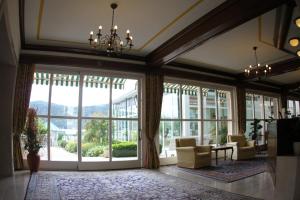 ein Wohnzimmer mit großen Fenstern und einem Kronleuchter in der Unterkunft SEEGLÜCK Hotel Forelle Superior in Millstatt