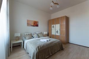 プラハにあるKubelikova APARTMEETのベッドルーム1室(ベッド1台付)、木製キャビネットが備わります。