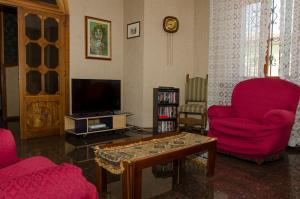 a living room with two red chairs and a coffee table at B&B Mamma Mia Family House in Peschiera del Garda
