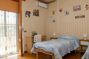 a bedroom with a bed with a blue blanket on it at B&B Mamma Mia Family House in Peschiera del Garda