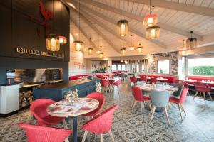 a restaurant with red chairs and tables and a counter at ibis Reims Tinqueux in Reims