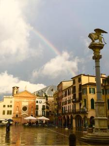 a rainbow over a city with a fountain and buildings at Appartamento al Duomo in Padova