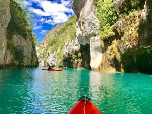 een rode kajak in het midden van een waterlichaam bij Le gite du grand cèdre - proche des gorges du Verdon in Allemagne-en-Provence