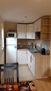 una cucina con armadi in legno e frigorifero bianco di Lara a Solochyn