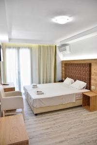 una camera con un grande letto e una sedia di Artemis Hotel Apartments a Hersonissos