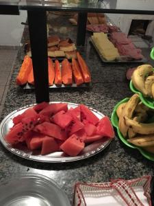 a plate of watermelon on a table with other food at Pousada Castelo Branco in Arapongas