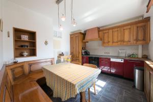 uma cozinha com uma mesa e armários vermelhos em Appartement T3 Aux Deux Cigognes Gries em Gries