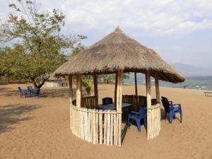 a gazebo with chairs and a table on the beach at Matema Lake Shore Resort in Matema Beach